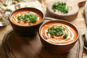 Two bowls of soup with herbs